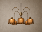 A vintage-style five-light chandelier with curved brass arms and textured amber glass shades, shown hanging against a neutral textured wall.