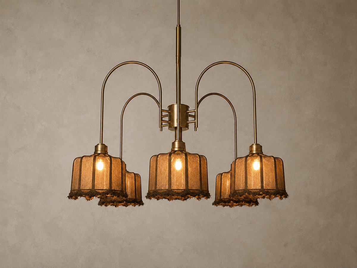 A vintage-style five-light chandelier with curved brass arms and textured amber glass shades, shown hanging against a neutral textured wall.