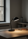 Black desk lamp on a wooden surface with a blurred background