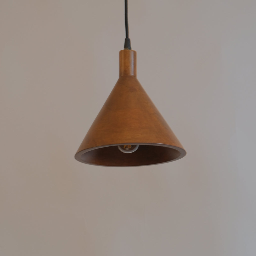 Brown pendant light hanging against a plain wall