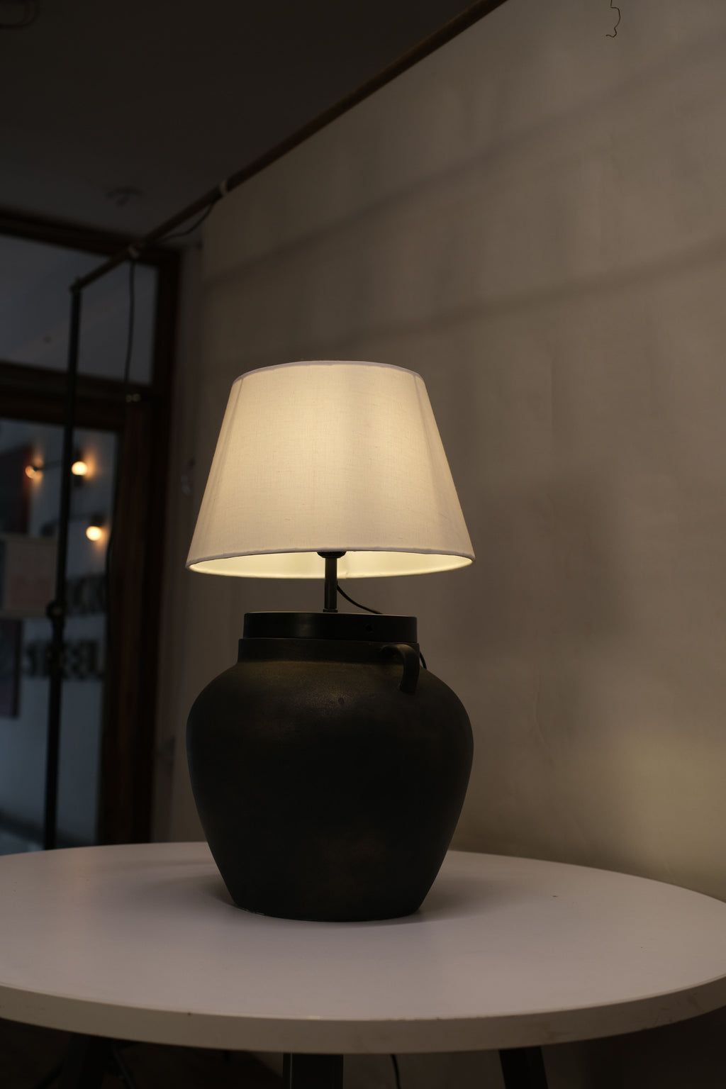 Chic table lamp with a sleek sand-textured base and a classic white shade, ideal for accenting any decor