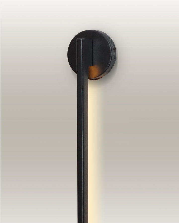 Contemporary LED linear wall lamp, featuring a minimalist black design and warm light for functional and ambient lighting.
