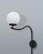 Contemporary arched wall lamp with a sleek black design and a soft-diffused white lampshade, mounted in a living room