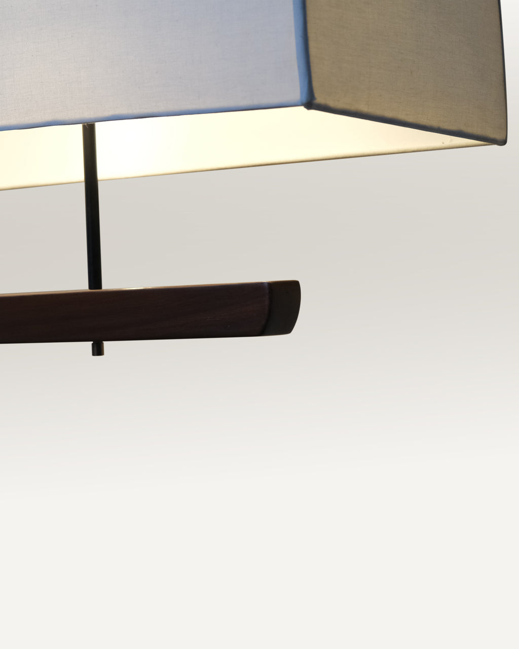 Contemporary dining light with a fabric shade and black rod suspension