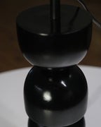 Designer table lamp with a unique stacked black base and contrasting white shade, perfect for interiors.