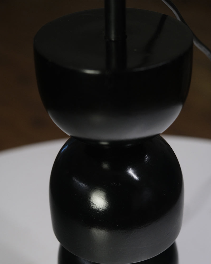 Designer table lamp with a unique stacked black base and contrasting white shade, perfect for interiors.