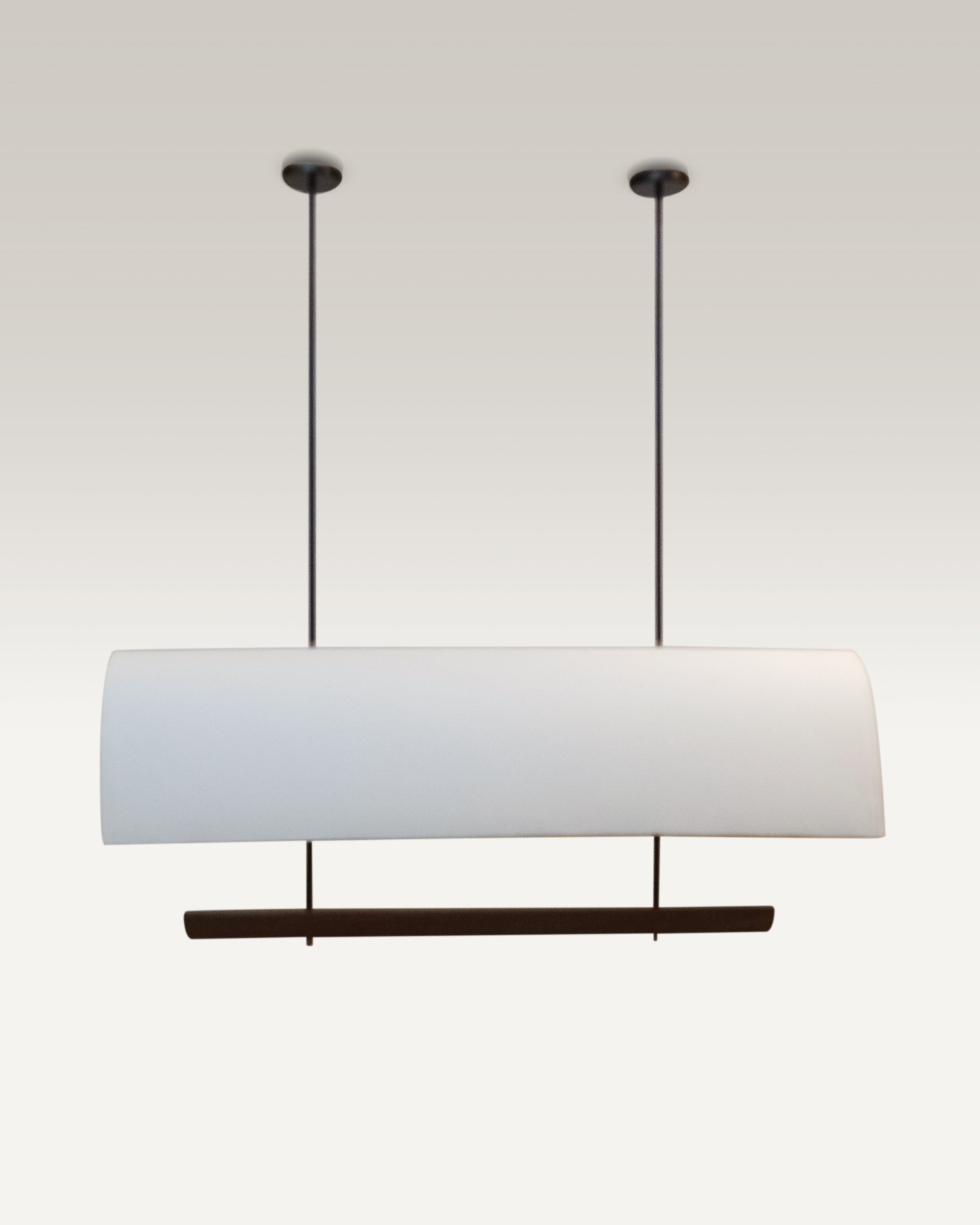 Edgy black rods suspend the luxe pendant dining light over a modern dining table.