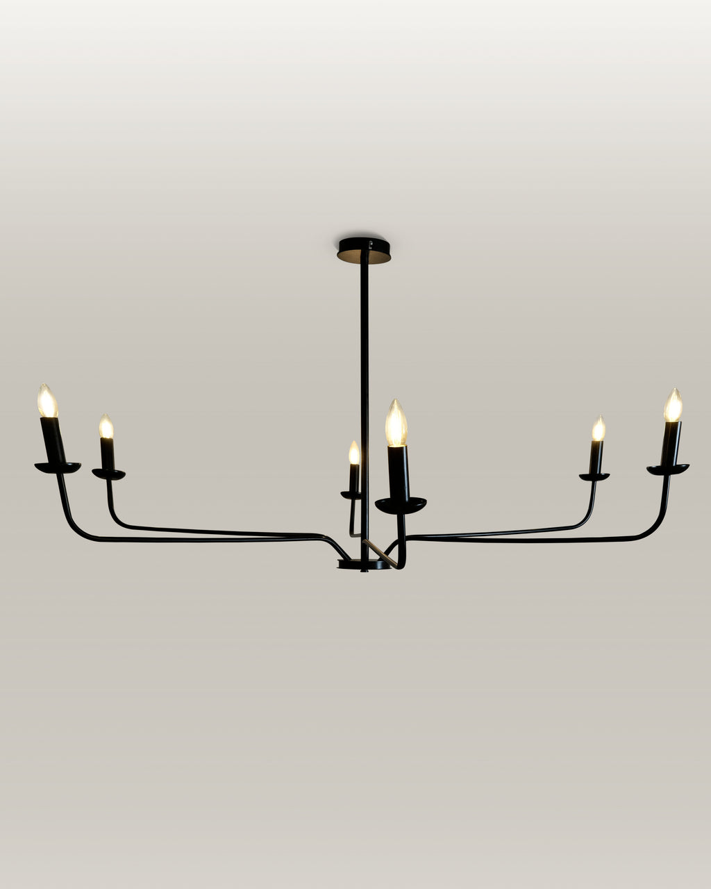 Elegant black metal chandelier with candle flame light bulbs, providing a warm glow in an entryway
