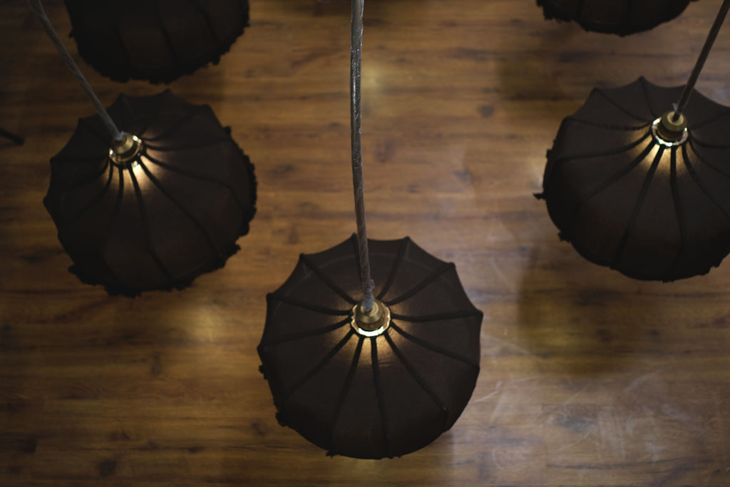 Elegant chandelier adorned with ornate glass designs, spreading soft light across a large ballroom.