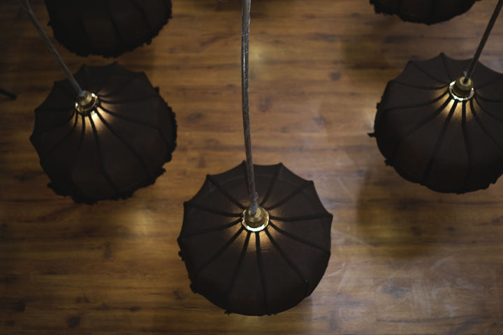 Elegant chandelier adorned with ornate glass designs, spreading soft light across a large ballroom.