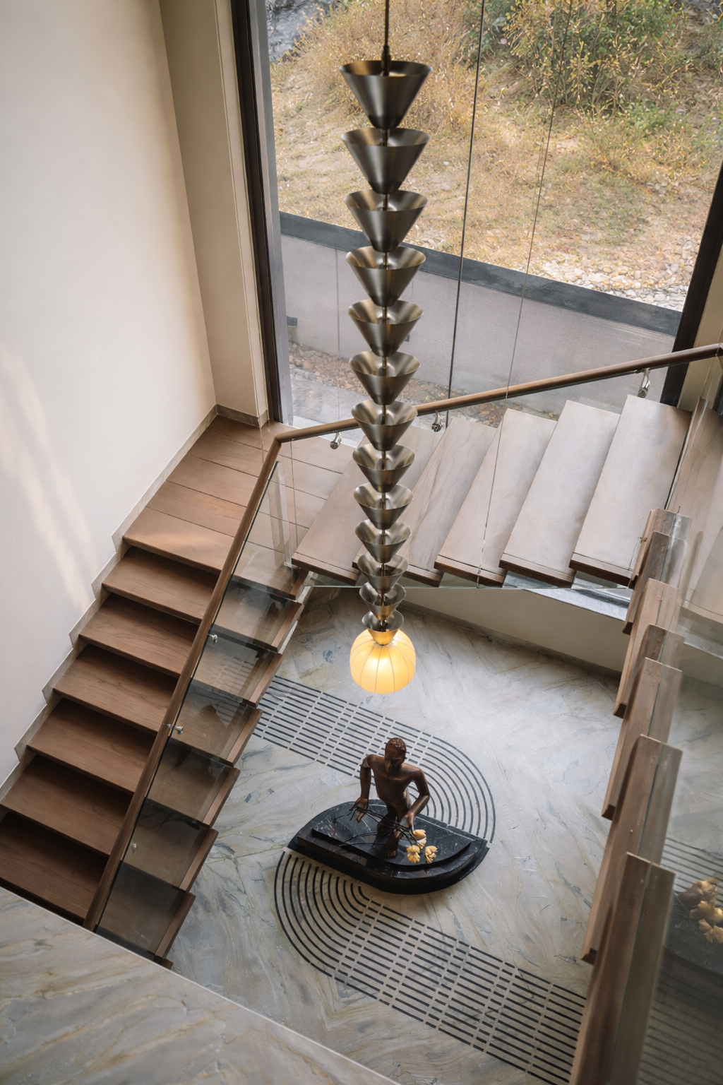 Modern staircase with a unique pendant light fixture and sculpture in a contemporary interior.
