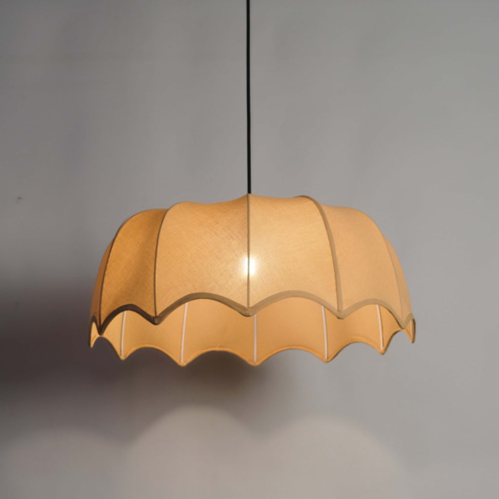 Elegant fabric pendant light suspended from a sleek black cord, perfect for dining and living spaces.