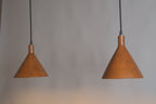 Two brown pendant lights hanging against a gray background