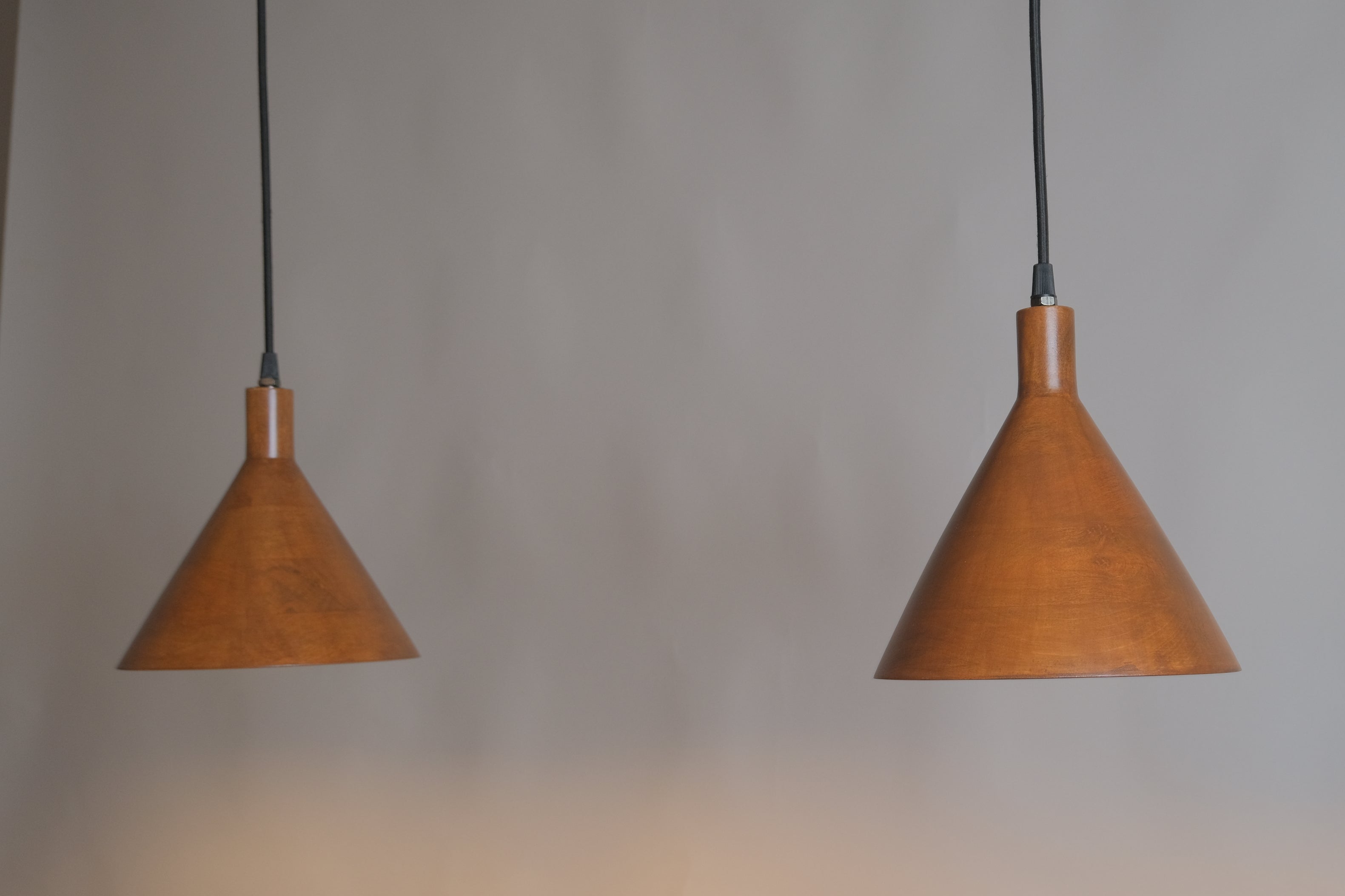 Two brown pendant lights hanging against a gray background