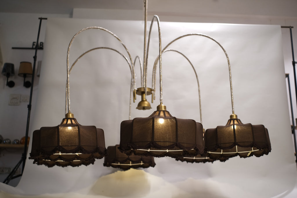 Luxurious modern chandelier featuring multiple tiers of warm glowing lights, suspended in a grand entryway.