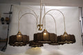 Luxurious modern chandelier featuring multiple tiers of warm glowing lights, suspended in a grand entryway.