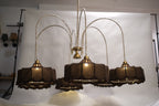 Luxurious modern chandelier featuring multiple tiers of warm glowing lights, suspended in a grand entryway.
