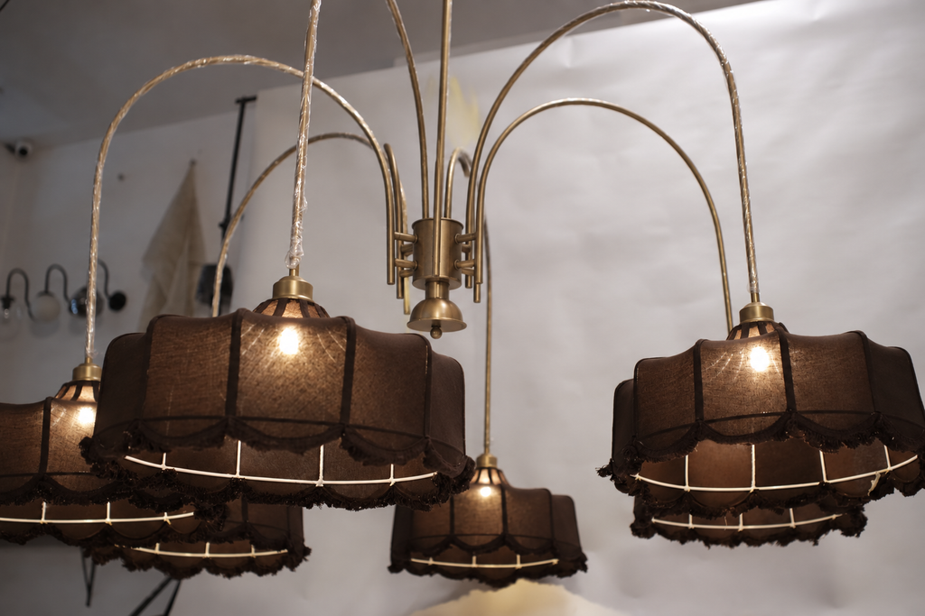 Luxurious modern chandelier featuring multiple tiers of warm glowing lights, suspended in a grand entryway.