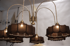 Luxurious modern chandelier featuring multiple tiers of warm glowing lights, suspended in a grand entryway.