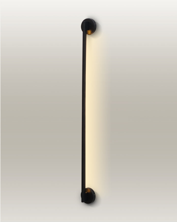Minimalist LED linear wall lamp with a slender design and warm glow, enhancing a modern room's ambiance