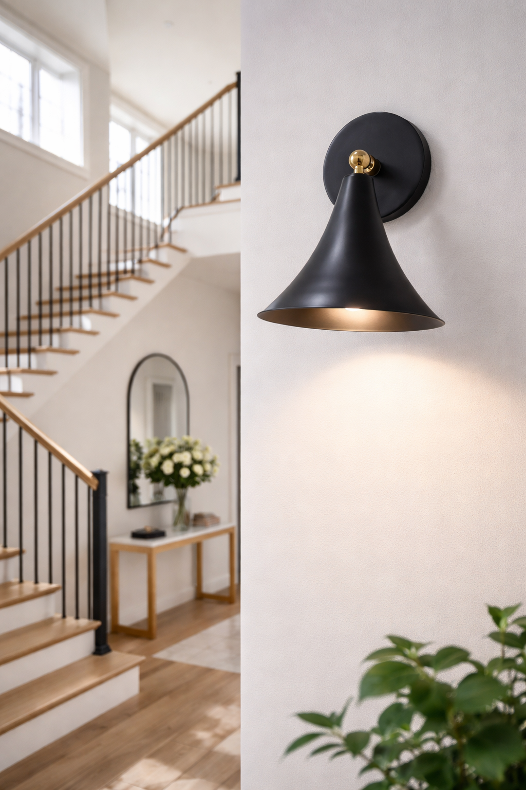 Modern black wall sconce in a home interior setting with staircase and decor.
