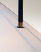 Modern dining room illuminated by an industrial luxe pendant light with black rods