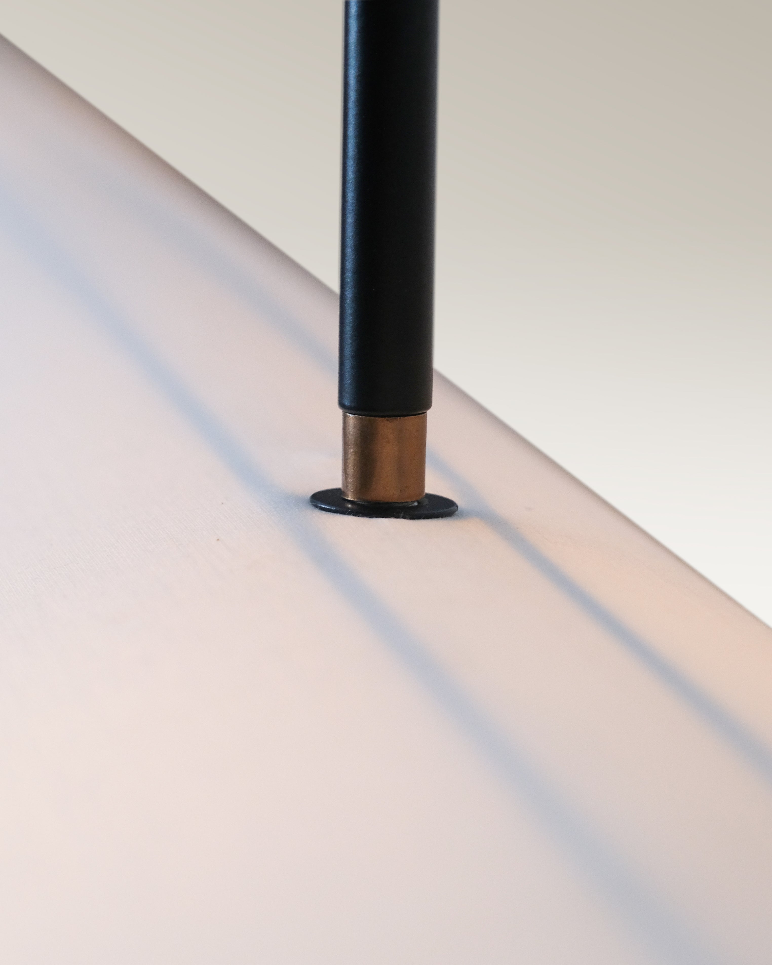 Modern dining room illuminated by an industrial luxe pendant light with black rods