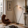 Modern floor lamp in a stylish living room with a brown chair and decorative items.