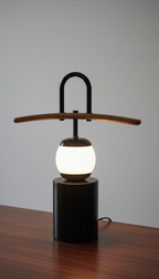 Modern table lamp with wooden arm on a wooden surface