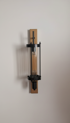 Modern wall-mounted light fixture with a metallic finish on a neutral background