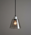 Pendant light with smoked glass shade and visible bulb on a gray background