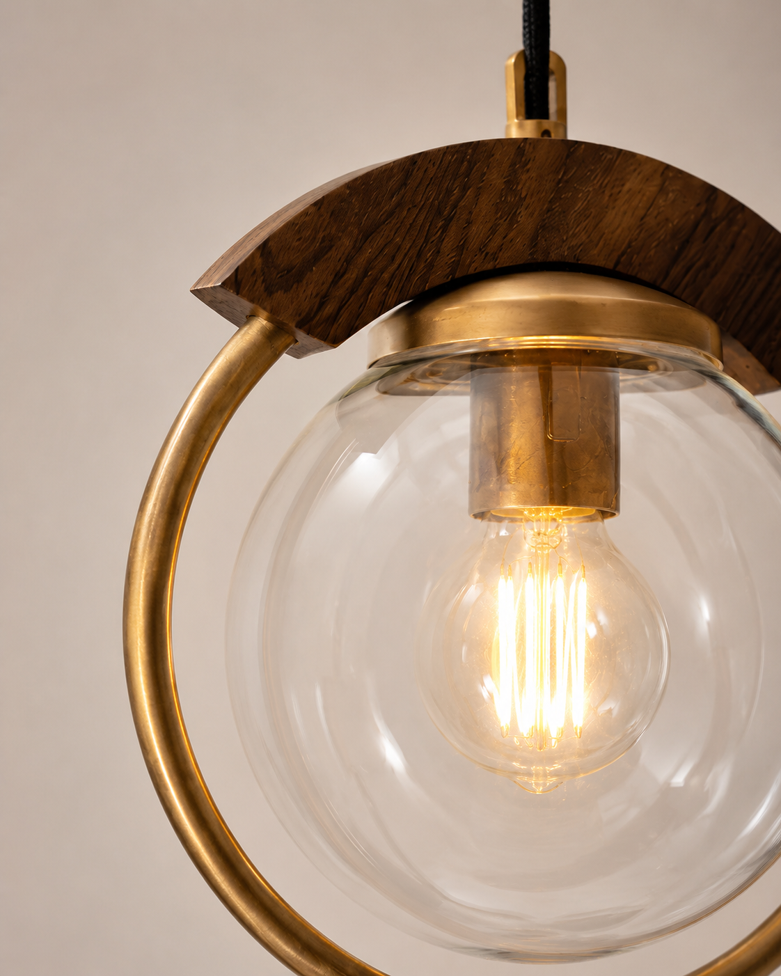 Pendant light with wooden and gold accents on a neutral background