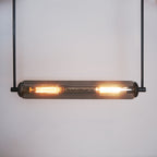 This modern lighting solution features an elongated glass tube encasing two glowing filament bulbs