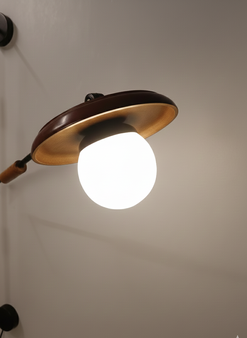 Wall-mounted light fixture with a round bulb on a neutral background