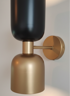 Wall-mounted light fixture with black and gold design on a neutral background