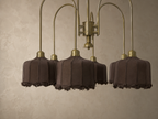 A multi-light chandelier with five dark brown fabric bell shades and fringed edges, suspended from curved brass-toned metal arms against a textured beige wall.