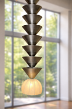 Modern pendant light with tiered design in a room with large windows.