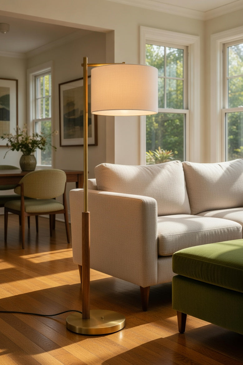 Living room with a white sofa, green ottoman, and standing lamp.