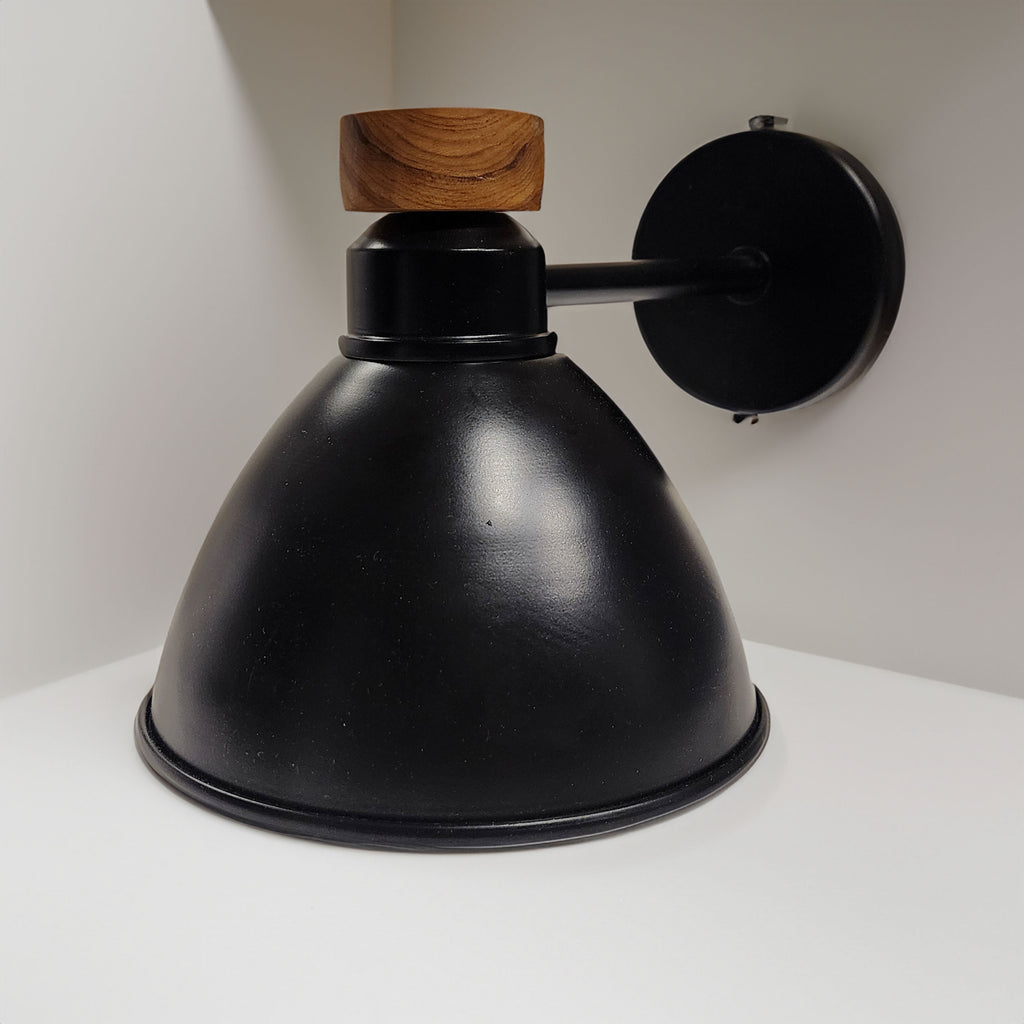 Modern black wall lamp featuring a conical shade and a wooden accent knob, mounted on a horizontal arm and round base. Ideal for adding a touch of elegance and functionality to any room.
