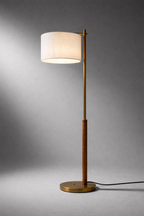 Floor lamp with a white shade and gold base on a gray background